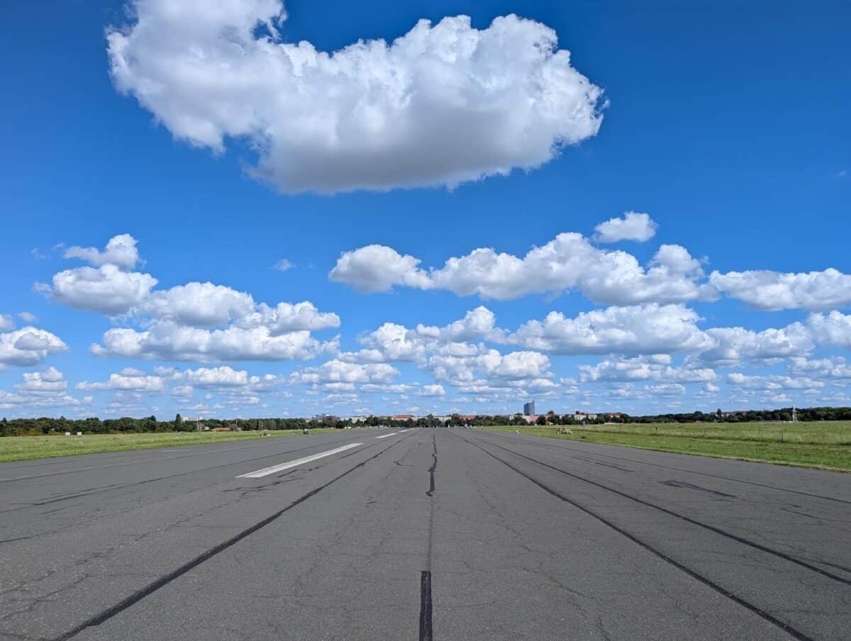 Leere Landebahn unter blauem Himmel mit Wolken.